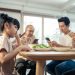 Upset daughter sitting at lunch table looking to addicted parents and grandparents using smartphones while eating breakfast. Ignoring Family not paying attention on small child. bad parenting in house