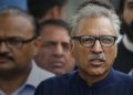 Pakistan Tehreek-i-Insaf party candidate Arif Alvi (C) walks back with party leaders after submitting papers for the presidential election outside the high court building in Islamabad on August 27, 2018. Pakistan will hold presidential elections on September 4. / AFP / FAROOQ NAEEM