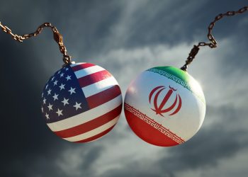 Wrecking balls textured with American and Iranian flags over dark stormy sky. Horizontal composition with copy space and selective focus. Dispute concept.